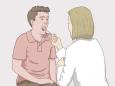 Un medic în timp ce prelevă o probă din gura unui bărbat, folosind un tampon