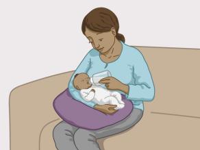 De moeder geeft de baby flesvoeding.