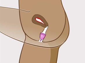 Laat de menstruatiecup los, hij gaat open in de vagina. Als de cup niet opent, draai hem een beetje. De cup zit volledig in de vagina.