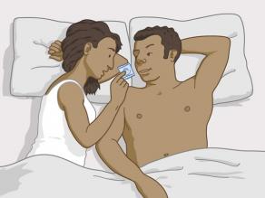 Een vrouw en een man praten in bed over anticonceptie