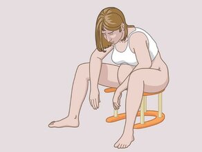 Femme soulageant sa douleur pendant l’accouchement : elle est assise sur un tabouret spécial.